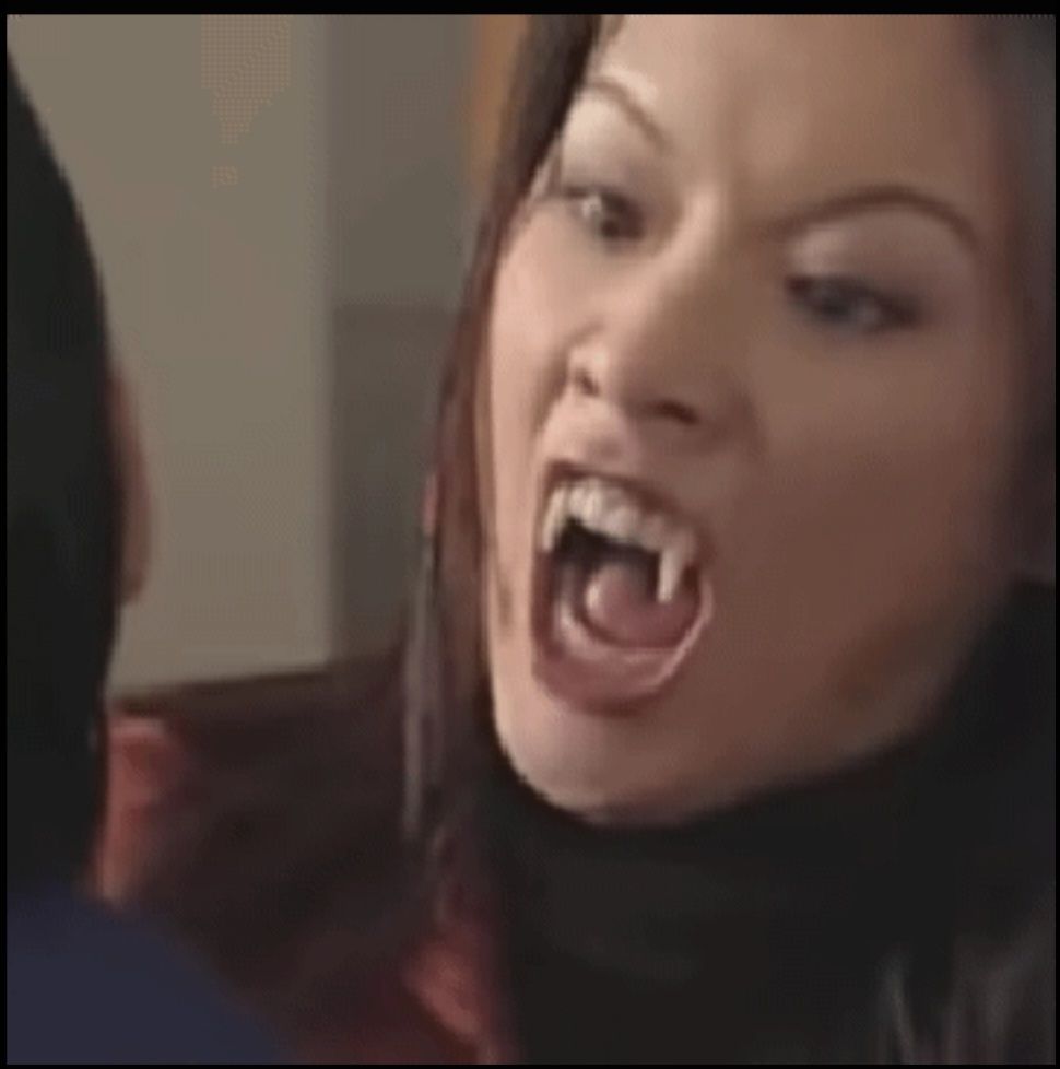 Daniella Monet as a vampire with sharp fangs, unhinged jaws, and hissing