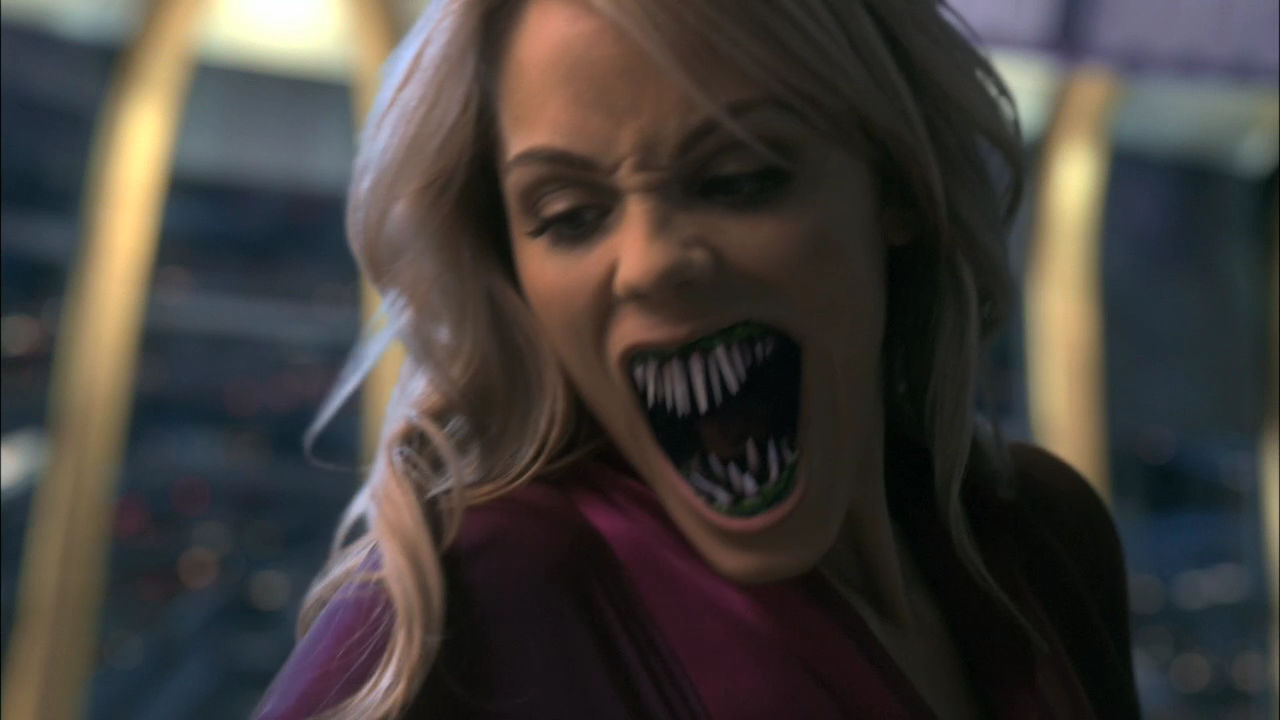 Elizabeth Lail as a roaring vampire with wide distended jaws and sharp fangs