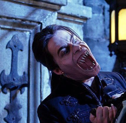 Elizabeth Lail as a vampire hissing with sharp fangs