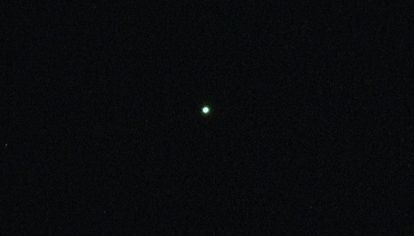 Big orb of white light flying in the air/ in the sky. Beautiful night sky full of stars as a background. 