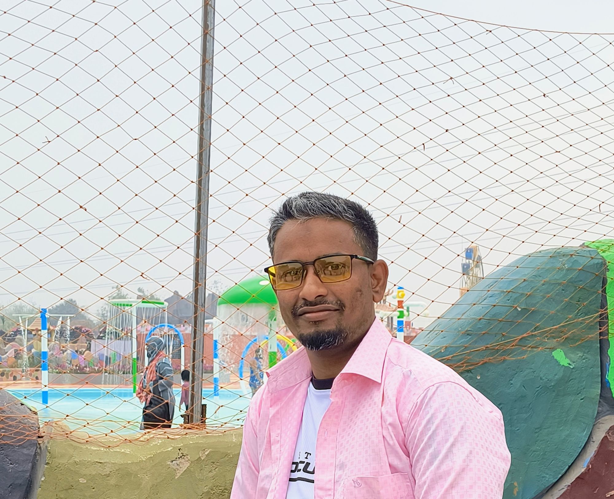 ""Photo-realistic 8K full-body portrait of this man I'm the above image leaning casually against a clean light-gray wall. He is wearing a is...