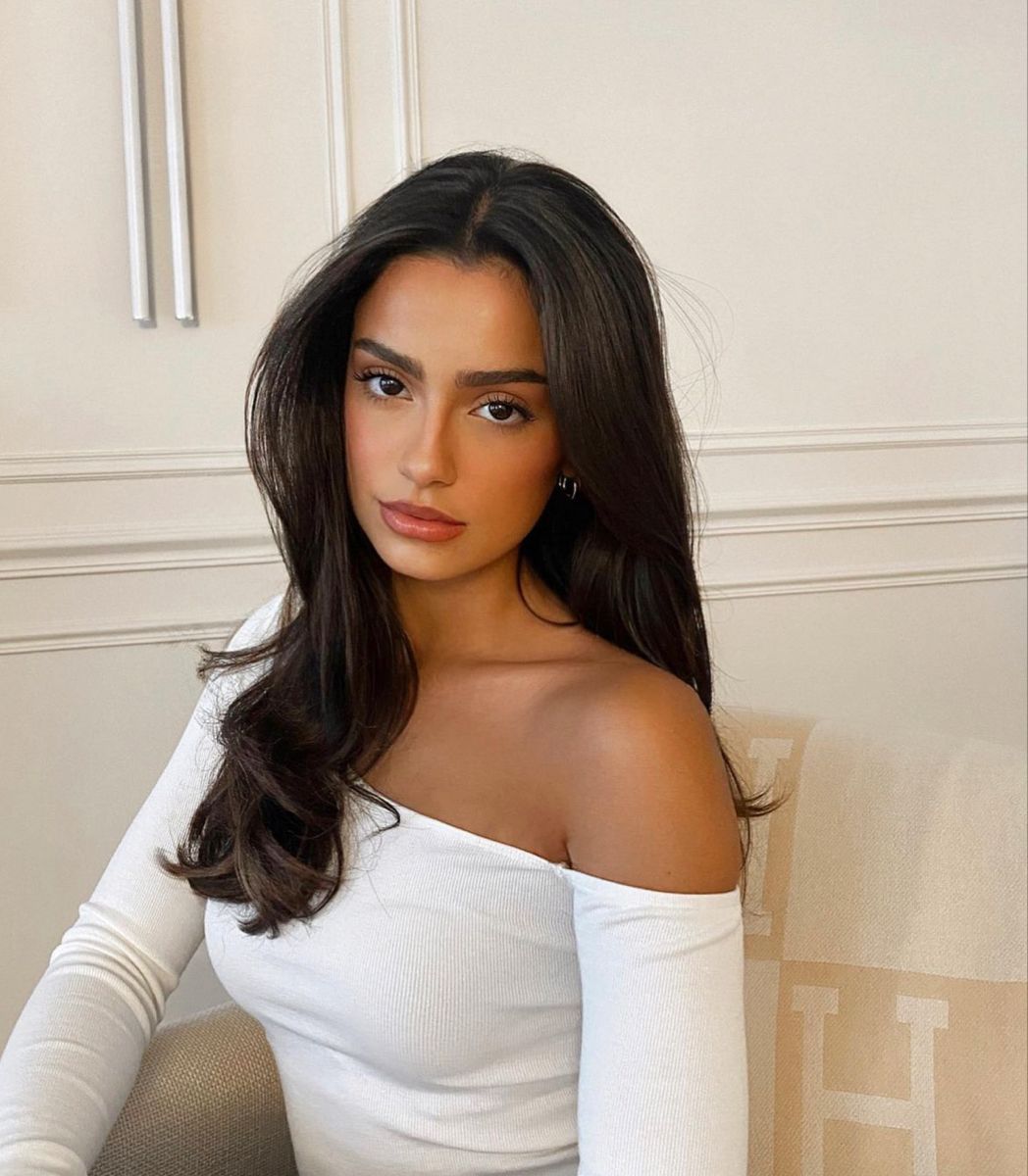 A photo from shoulders to head. A beautiful girl, with elegant style. dark-haired man looks out the window of an airplane. A nice sunny sky.