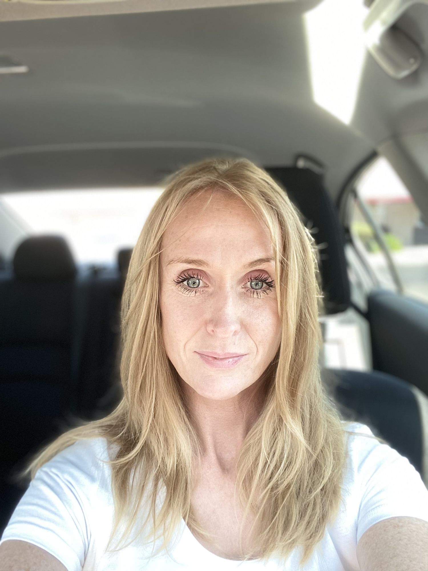 A woman appearing to be in her early to mid to late 30s, posing for a mirror selfie in a soft, dim-lit interior.

Appearance and Style:

• H...