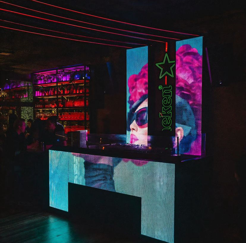 A Suspiria themed party at a luxury nightclub's bar, with red, purple and blue lights and people in halloween costumes dancing, art nouveau...