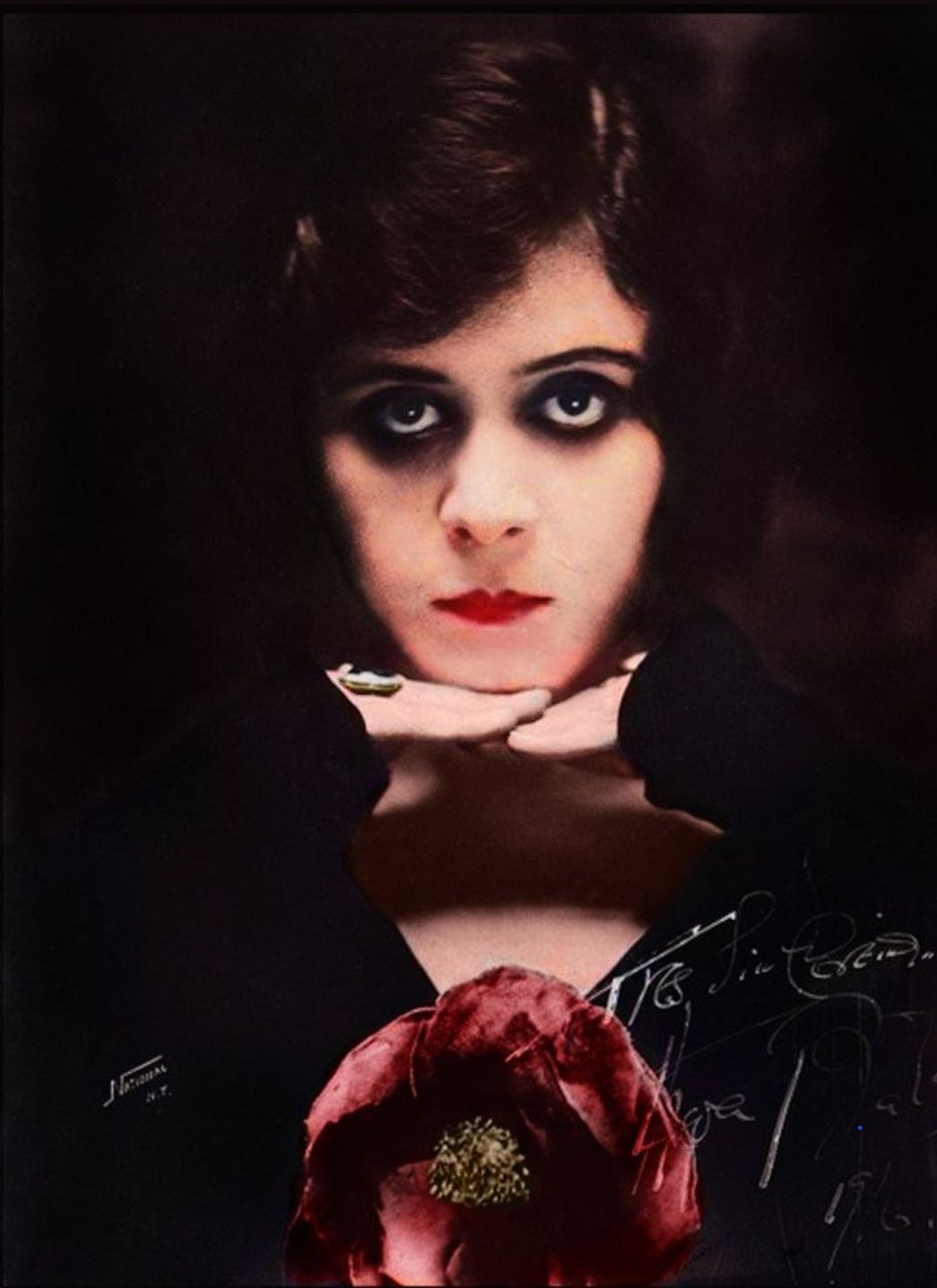 Gothic portrait photography. Waist-up portrait. A solitary goth beauty with pale skin and dark hair, sits in a dimly lit, ornate chair, ador...