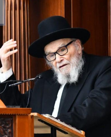 בנוף ענבר של שקיעת השמש, הרב משה הלל הירש מנהיג הציבור הליטאי, לבוש בפראק מכובד, אל מול הרקע של ישיבת סלבודקא בבני ברק, צלליות ארוכות, הרב י...