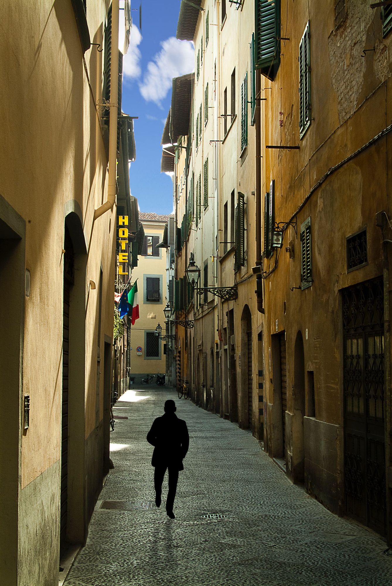 The silhouette of a man walking down a narrow street in Mont Saint Michel