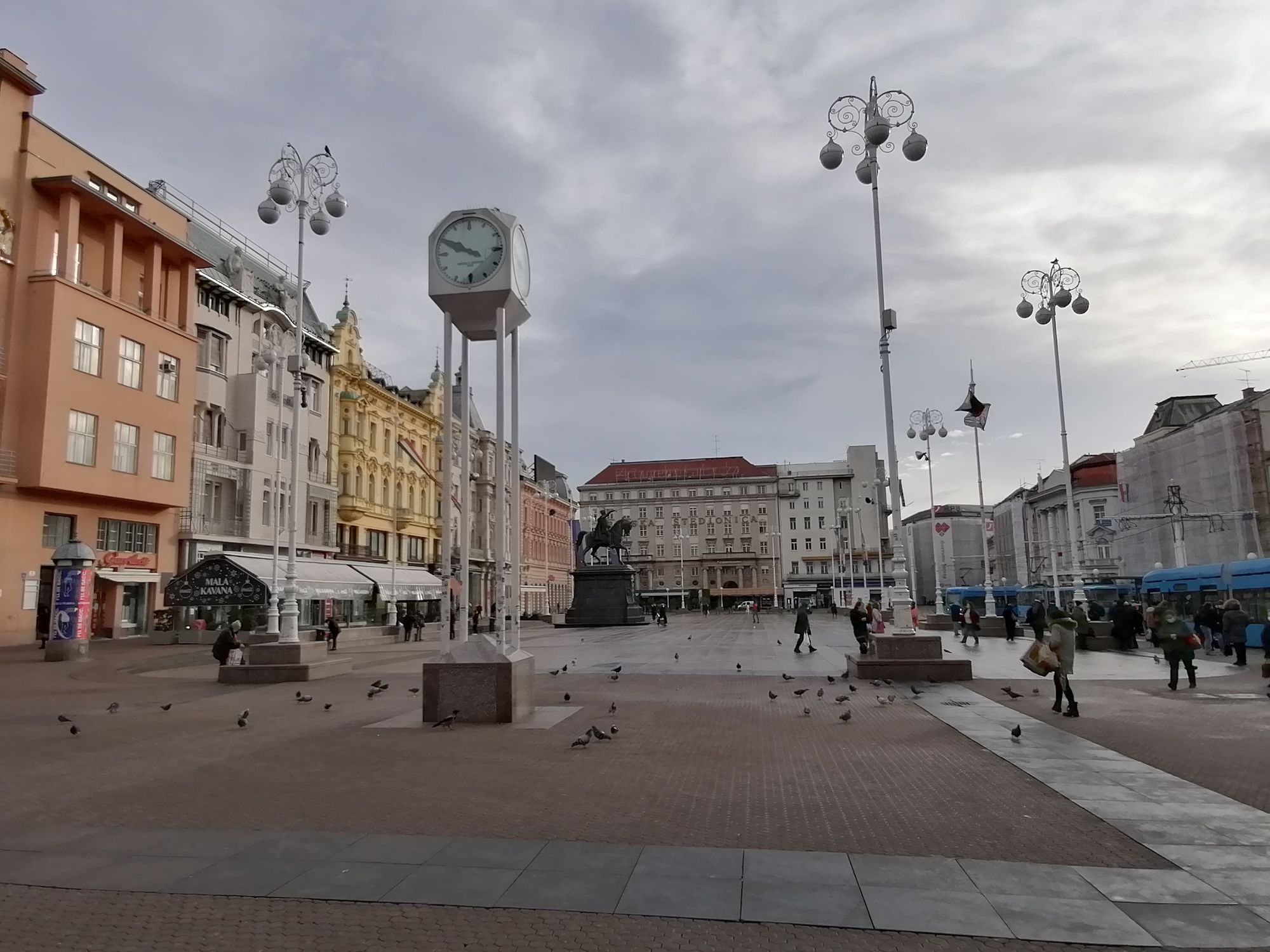 zagreb, croatia, with a statue of ban Jelačić on a horse, behind the big clock in the middle of the square, all in black and white with redd...