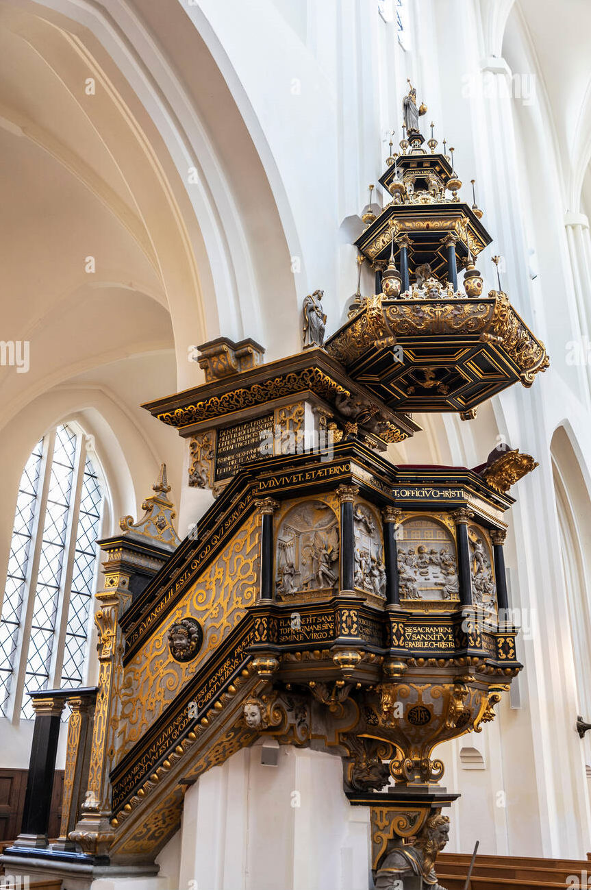 A Duergar, standing in a metal feeding cage with a wooden exit door built into the adjacent wall (1) high above the floor of a water filled...