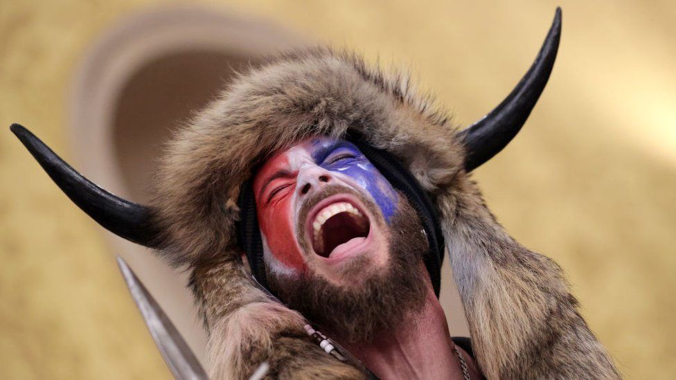 QAnon shaman Jacob Chansley in a screaming pose, mid-action, painted in the style and cour palette of Otto Dix