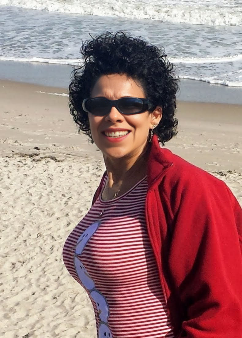 Brunette beauty wearing sun glasses, at the beach, red bikini,m, red jacket, wind blown hair.