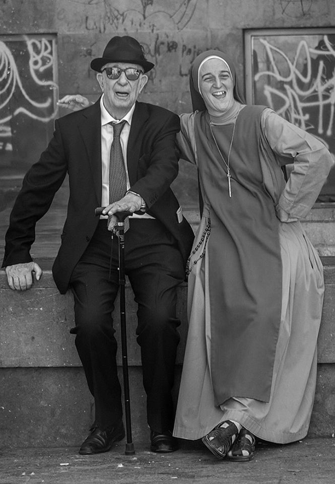Blind man with female priest against graffiti wall