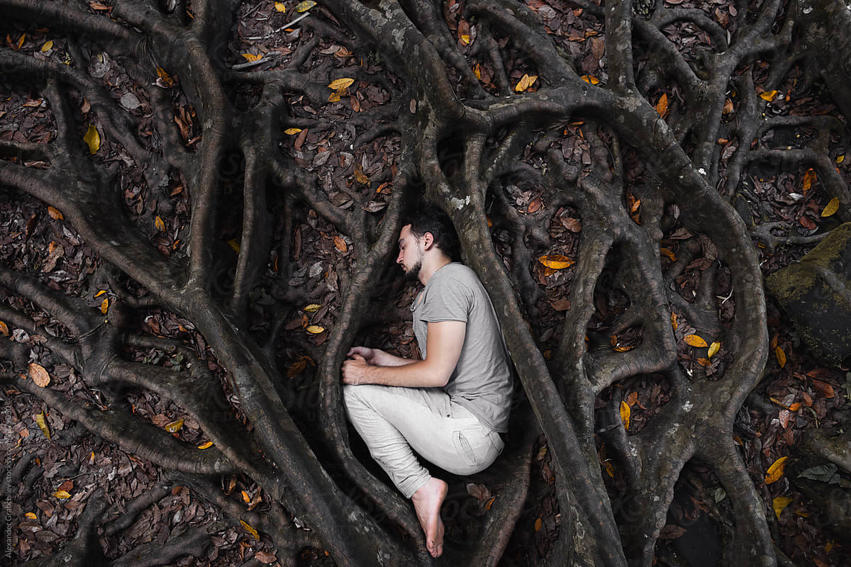 A man with anxiety and worries being trapped by roots.