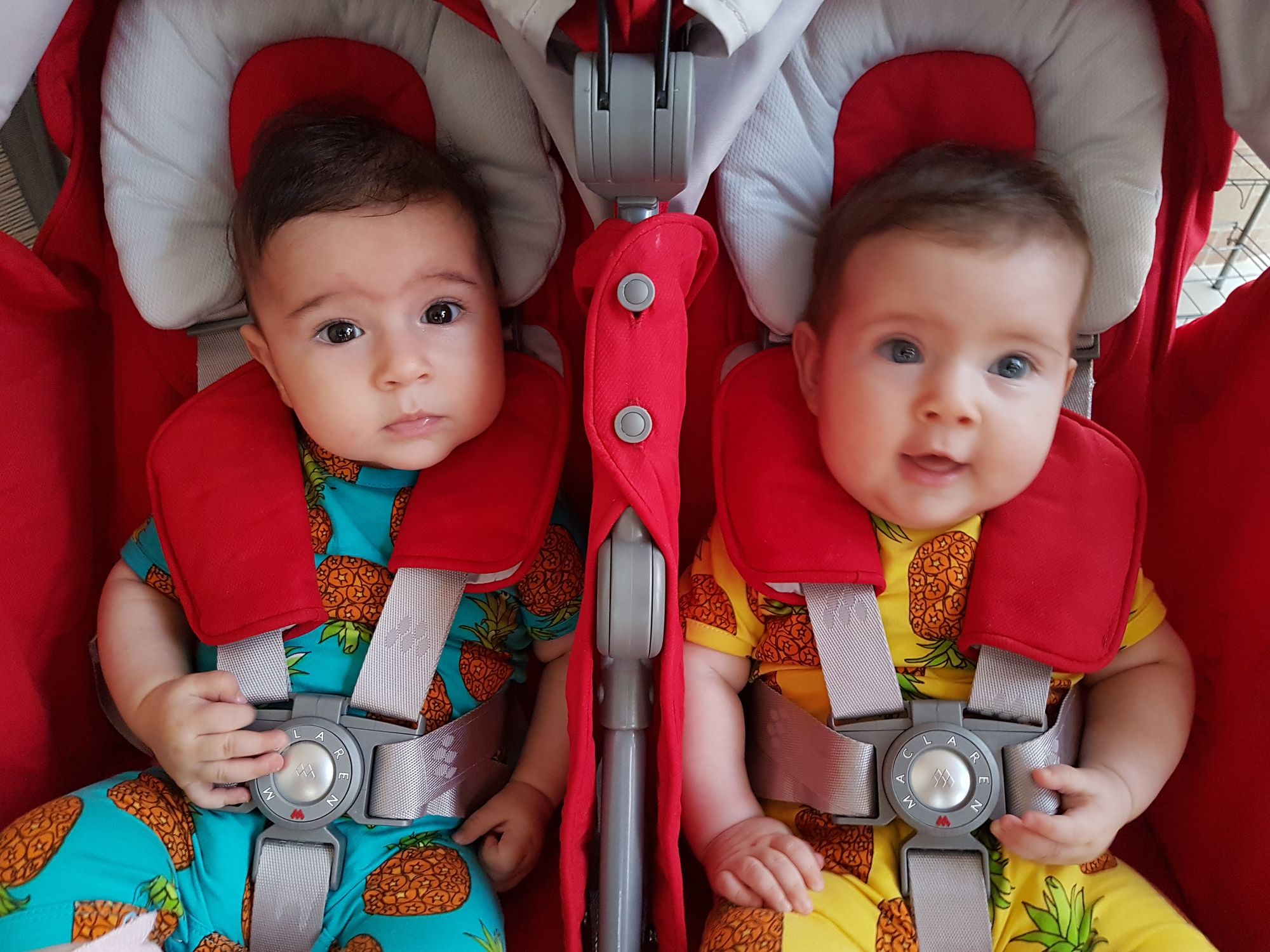 Two newborn baby girls, dressed in astronaut suits, escape from the burning world inside a space rocket. The one on the left has black hair...