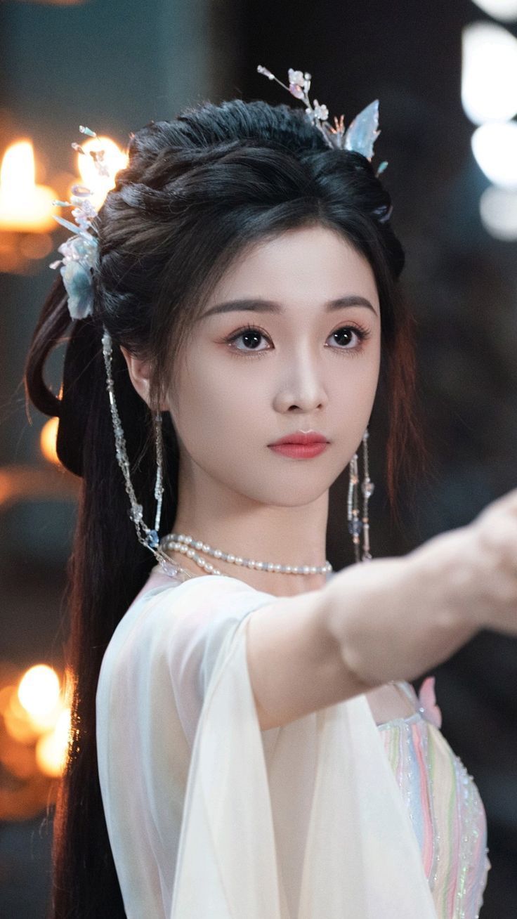 Edit close-up photo of Wu Xuanyi to transform her into a Lunar Fairy while preserving her real facial features and natural skin texture. She...