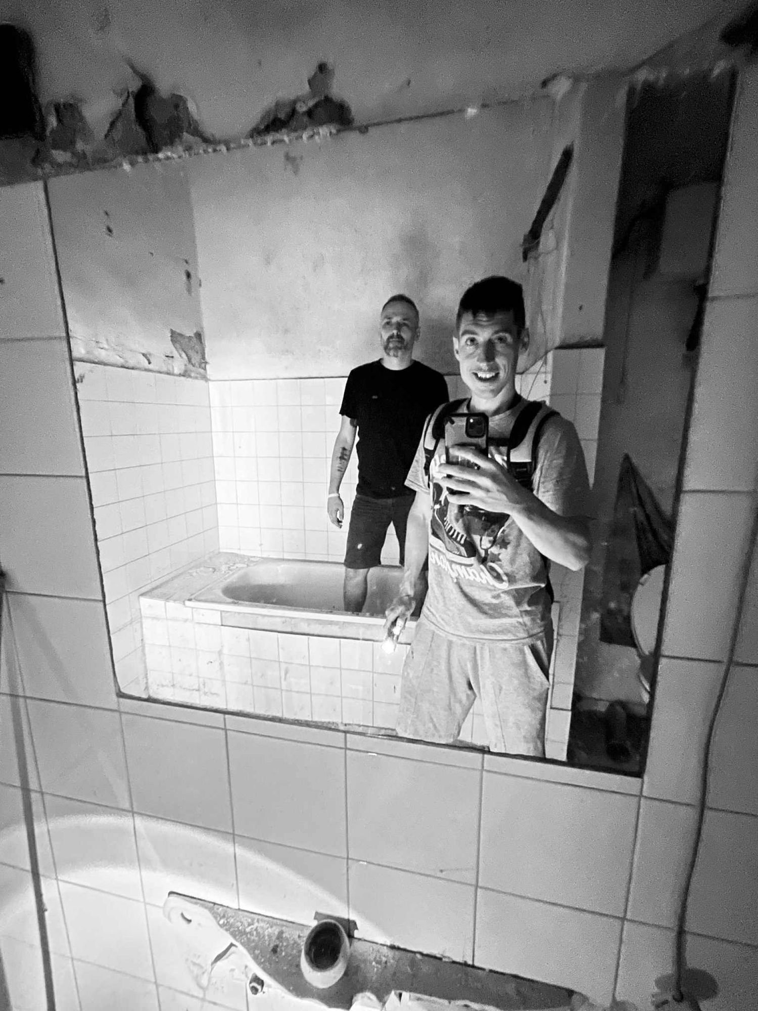 this photo of 2 men working in a bath, only full color and in the style of The Simpsons