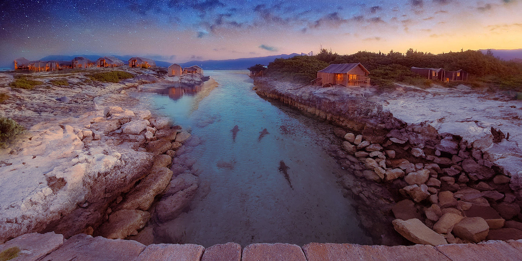 fantasy style magical beach with fairy houses with glowing windows on the right side of the image