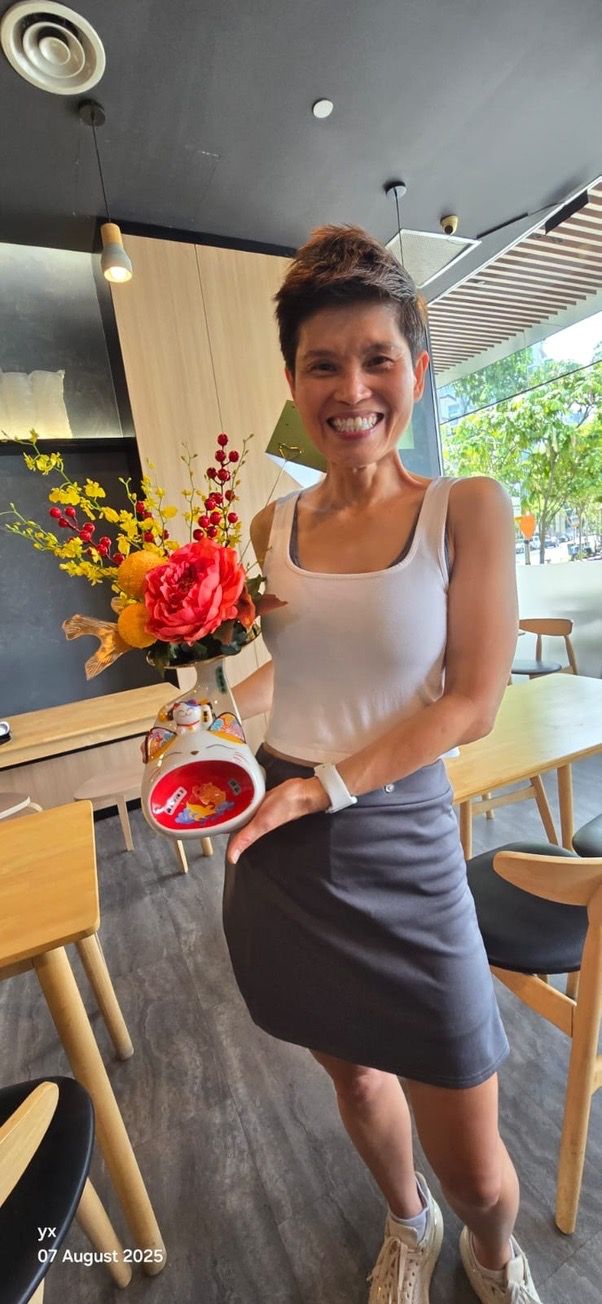 Depict me (use my face exactly as in the uploaded photo) sitting on a flying drone with my legs fully dangling, laughing and looking at the ...