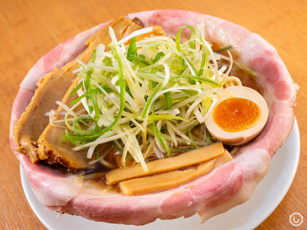 this dish is a beautifully plated and appetizing combination of grilled chicken, noodles, fresh greens, soft-boiled eggs, and a mix of vibra...