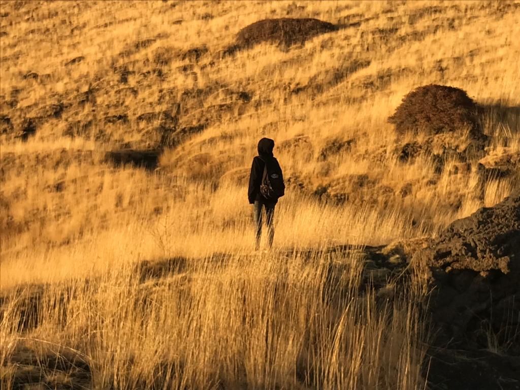 a girl in black hoodie in a field of grass
