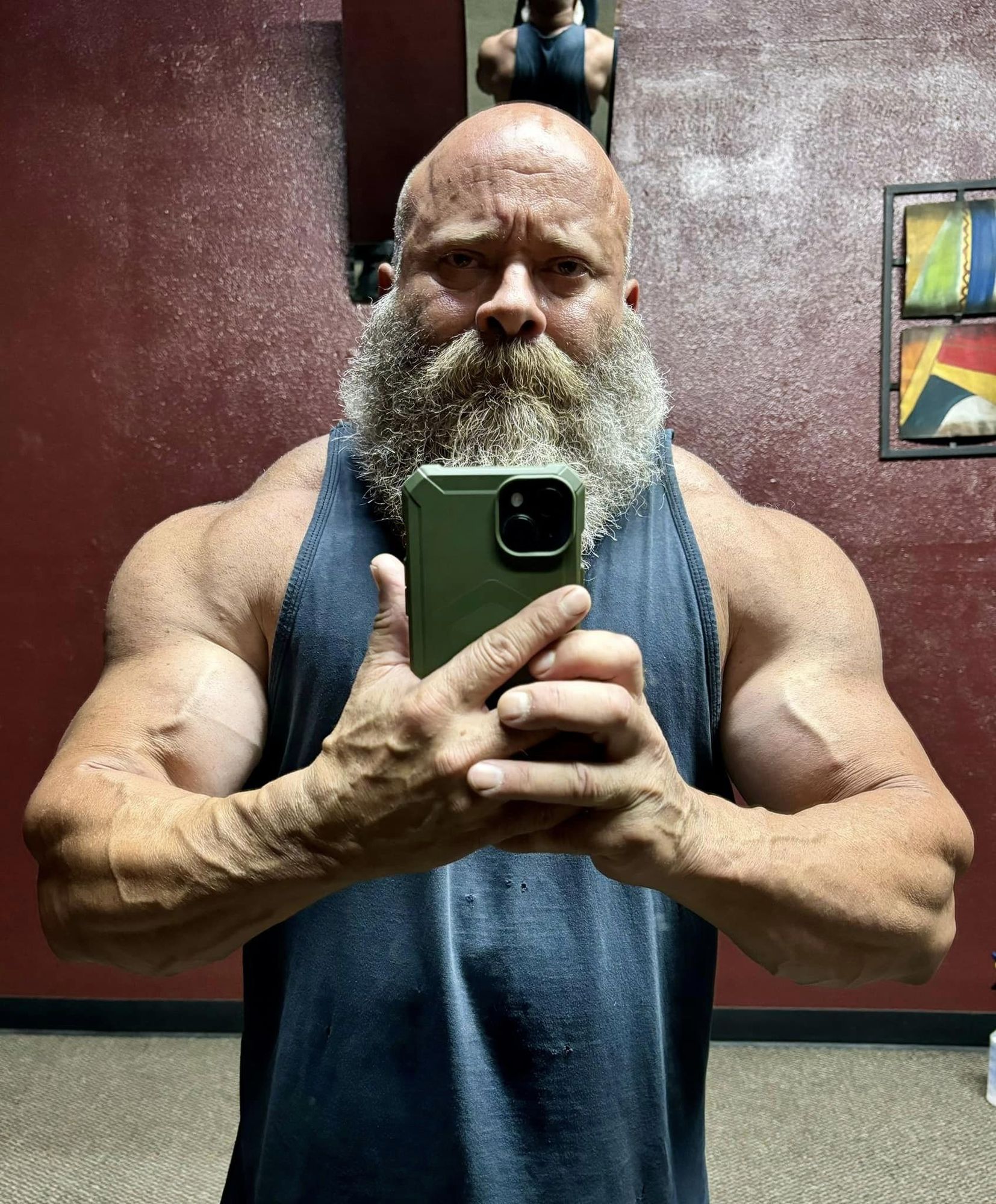 Front view of a muscular and massive 55 year old power-lifter, oiled and ready for a bodybuilding competition, Venezuelan grandfather, short...