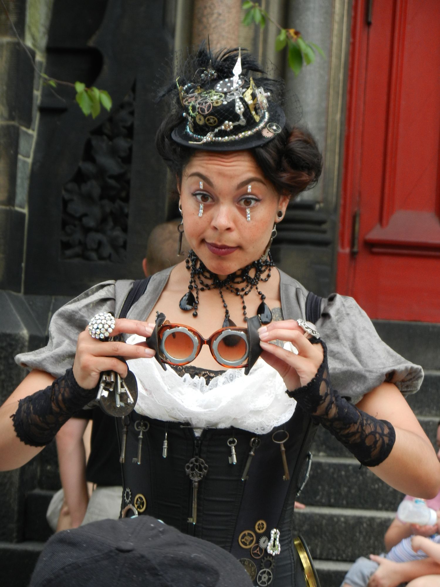Woman wearing a hat and holding goggles.