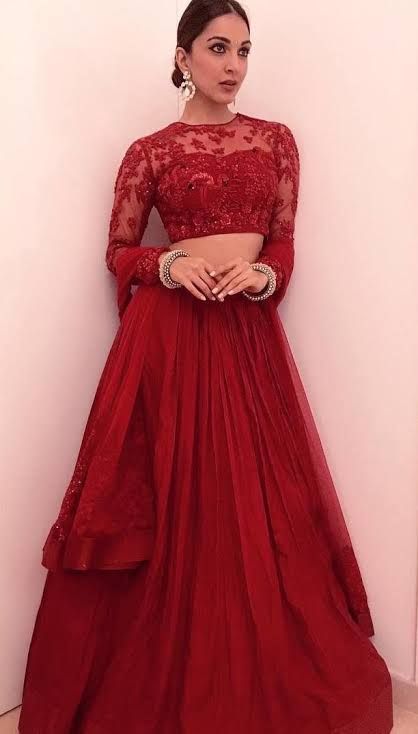 Her in maroon red wedding lehenga  with long straight Braided hairstyle with hairs parted with centre and red glossy lipstick with tradition...