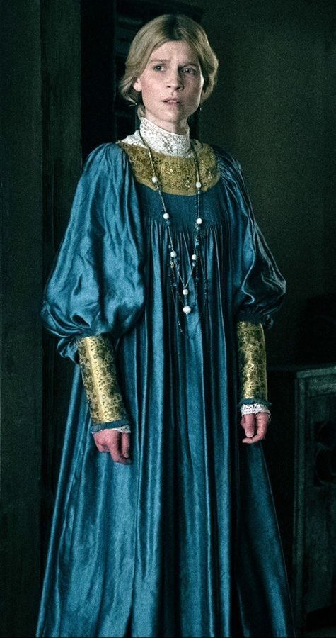 A young warrior lady has light blonde curly realistic hair. She has a puffy medieval Blue dress With many gold Armor détails on her dress. M...