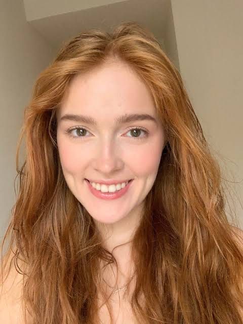 /image Create a highly detailed digital illustration of a serene winter scene. I want to see a gorgeous 30-something redhead sitting on a be...