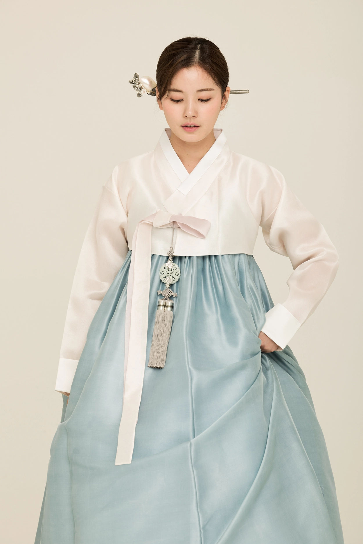 In a sun - drenched, secluded garden nook, where ancient tree branches form a natural canopy, a person dons a slightly worn, crisp white cot...