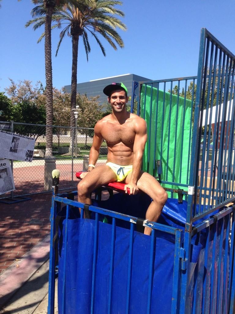 clear dunk tank booth,  shirtless young men 