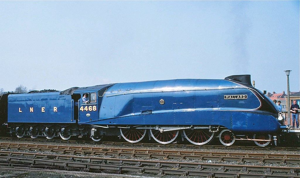 <lora:Antique Watercolor:1.0> This is a surreal, hyperrealistic portrait of the Mallard steam locomotive framed by a grungy industrial lands...