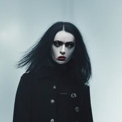 closeup portrait of beautiful female goth fashion model, decayed inner city. cracked sidewalks. burning buildings. abandoned cars. broken gl...