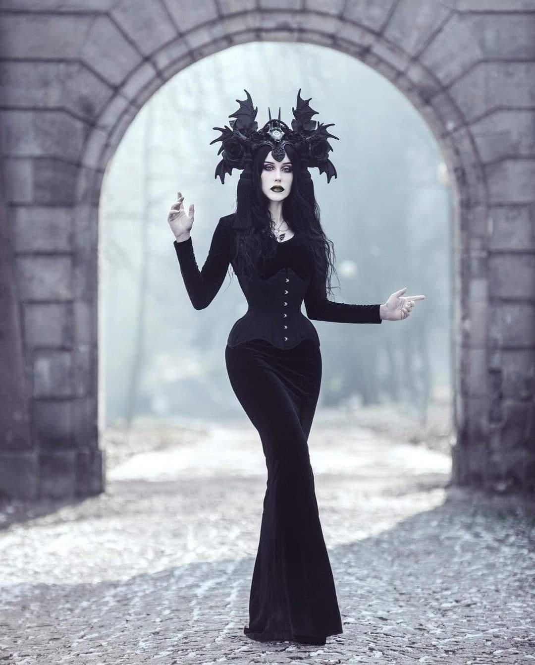 A woman of darkness, a goth with hips, curvy, in a castle door, with the moonlight glistening on her pale skin