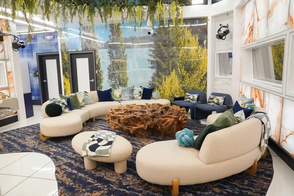 Bioluminescent Crystal Gemstone Cavern themed Living room inside The Big Brother House, beautiful couches and chairs surrounding a crystal s...