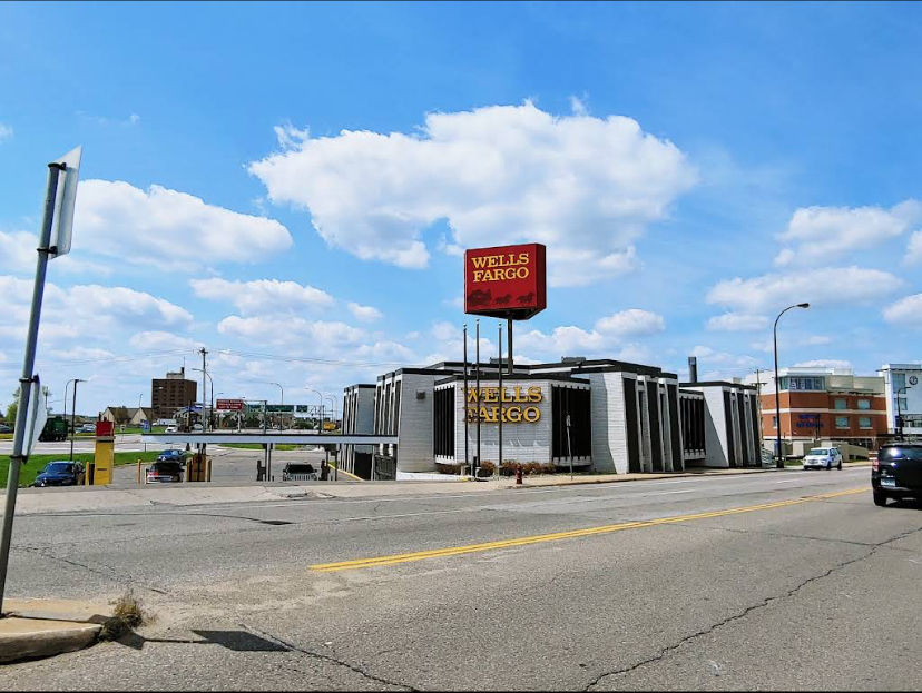 Use watercolor style to remake the given image, add 3 people of different ethnicities standing at the
front of the Wells Fargo bank