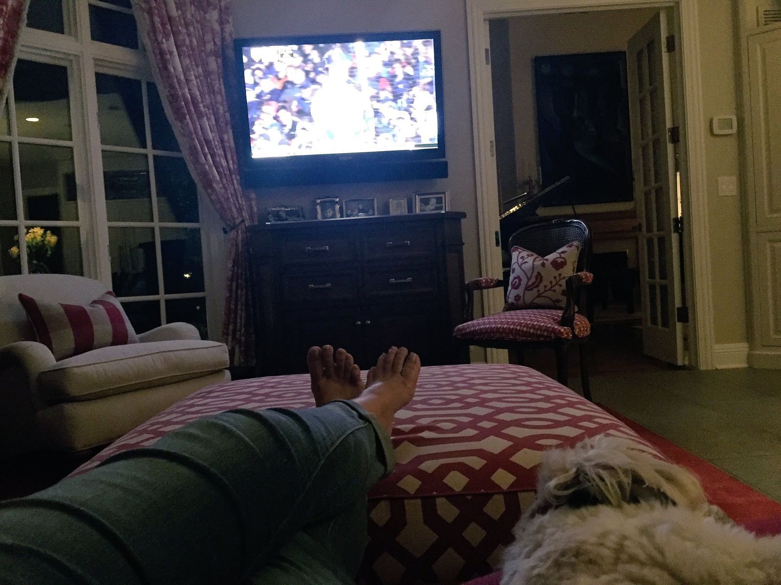 Watchinng TV crossing and then recrossing her ankles and feet