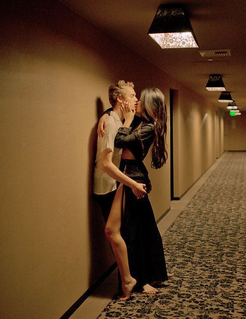 Cheating wife kissing boyfriend in hallway of hotel