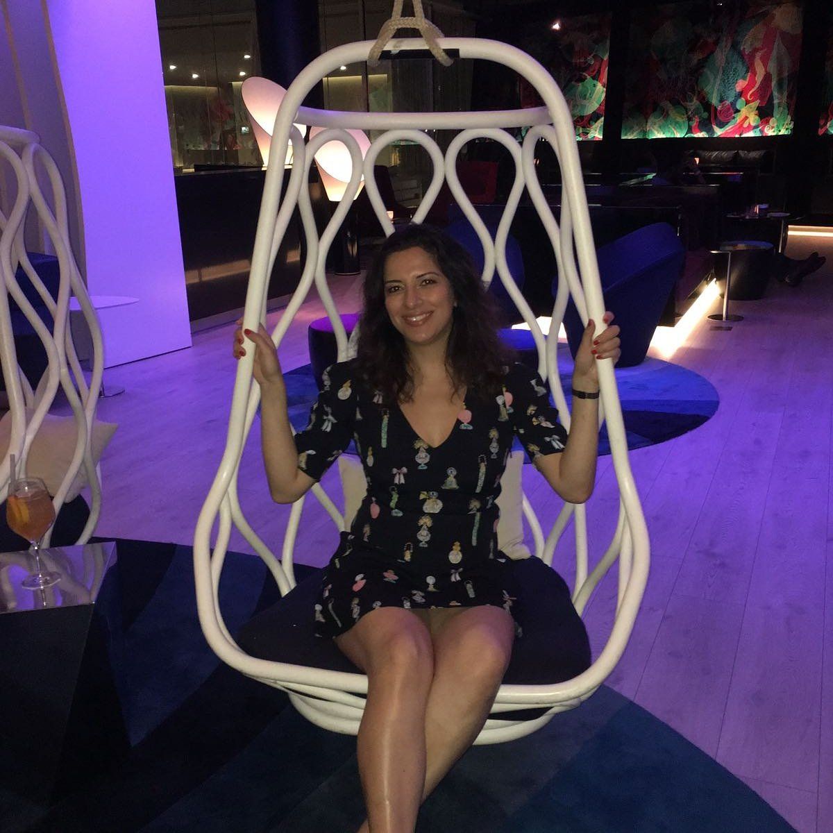 Rocking gently back and forth, extending her legs, smiling at you