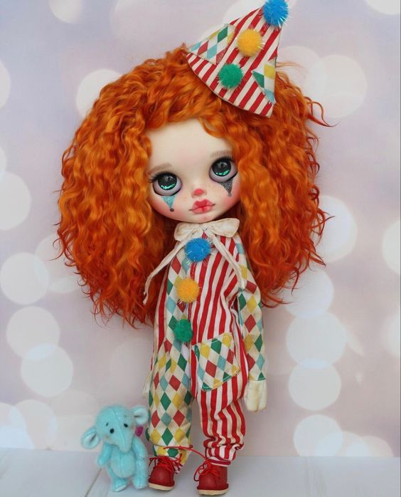 Cute clown blythe doll with sad face with dramatic lighting. In the background you can see colorful confetti and flying streamers.