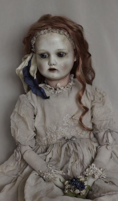 Very terrifying antique doll that looks like a zombie in a hellish environment with very dramatic lighting.