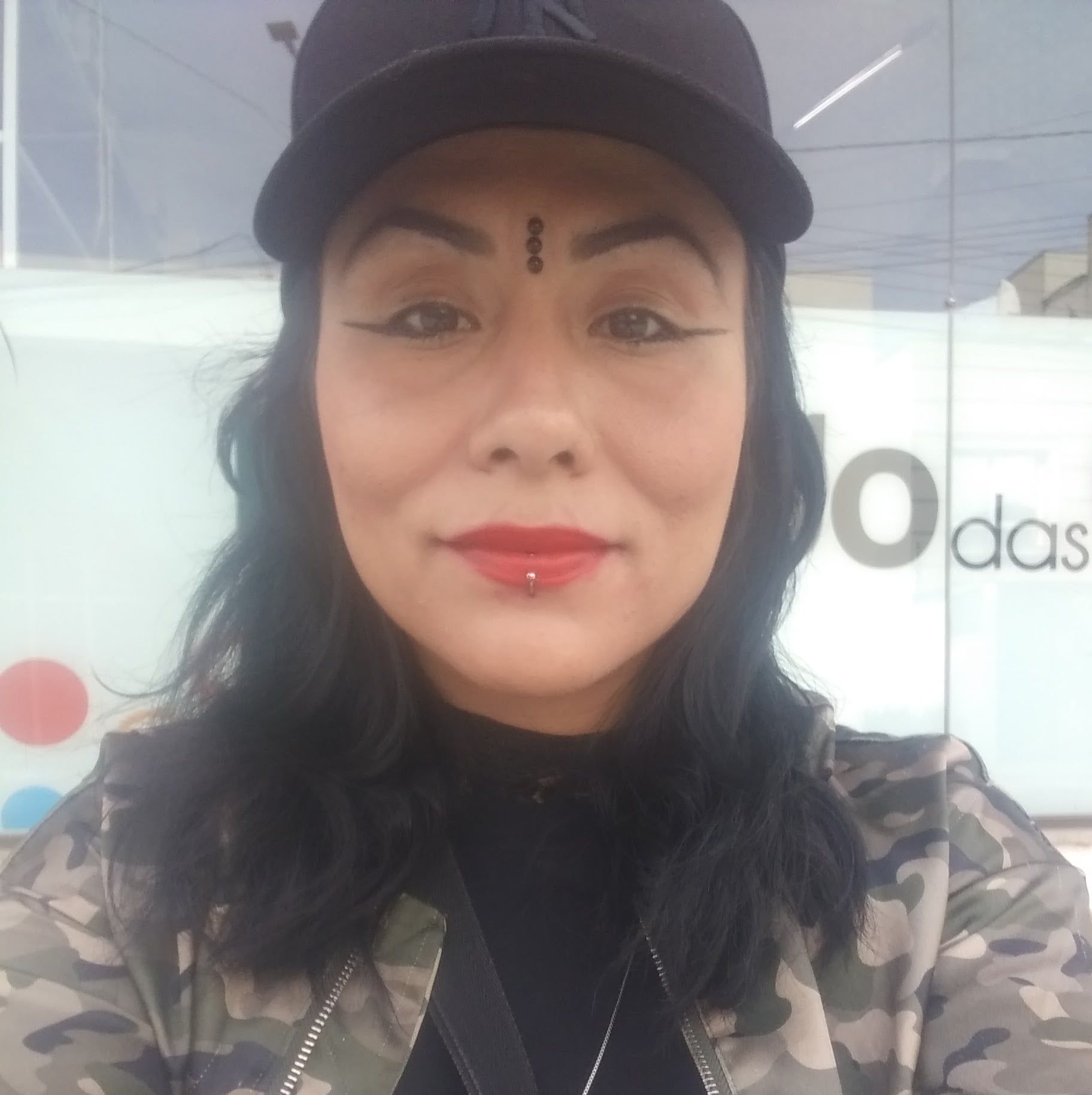 A cute miniature baby dragon sitting in a glass jewelry box overflowing with glowing glass jewelry.