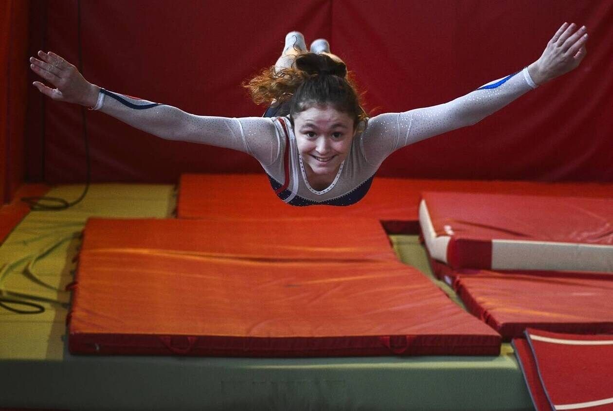 the iconic and stunning picture of a gorgeous beautiful ninja woman in action, jumping from the flaming roof of an old cursed temple , savag...