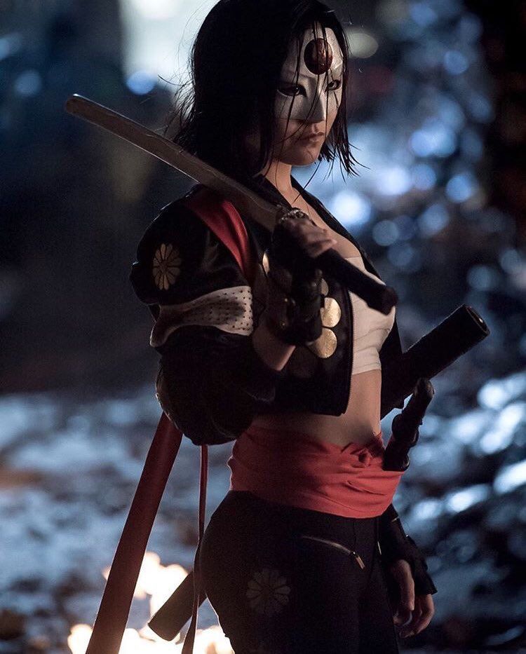 A frightening photography of an Indian, barbarian savage muscular warrior woman, blending elements of a Thug and a Ninja.she is in a dark ol...