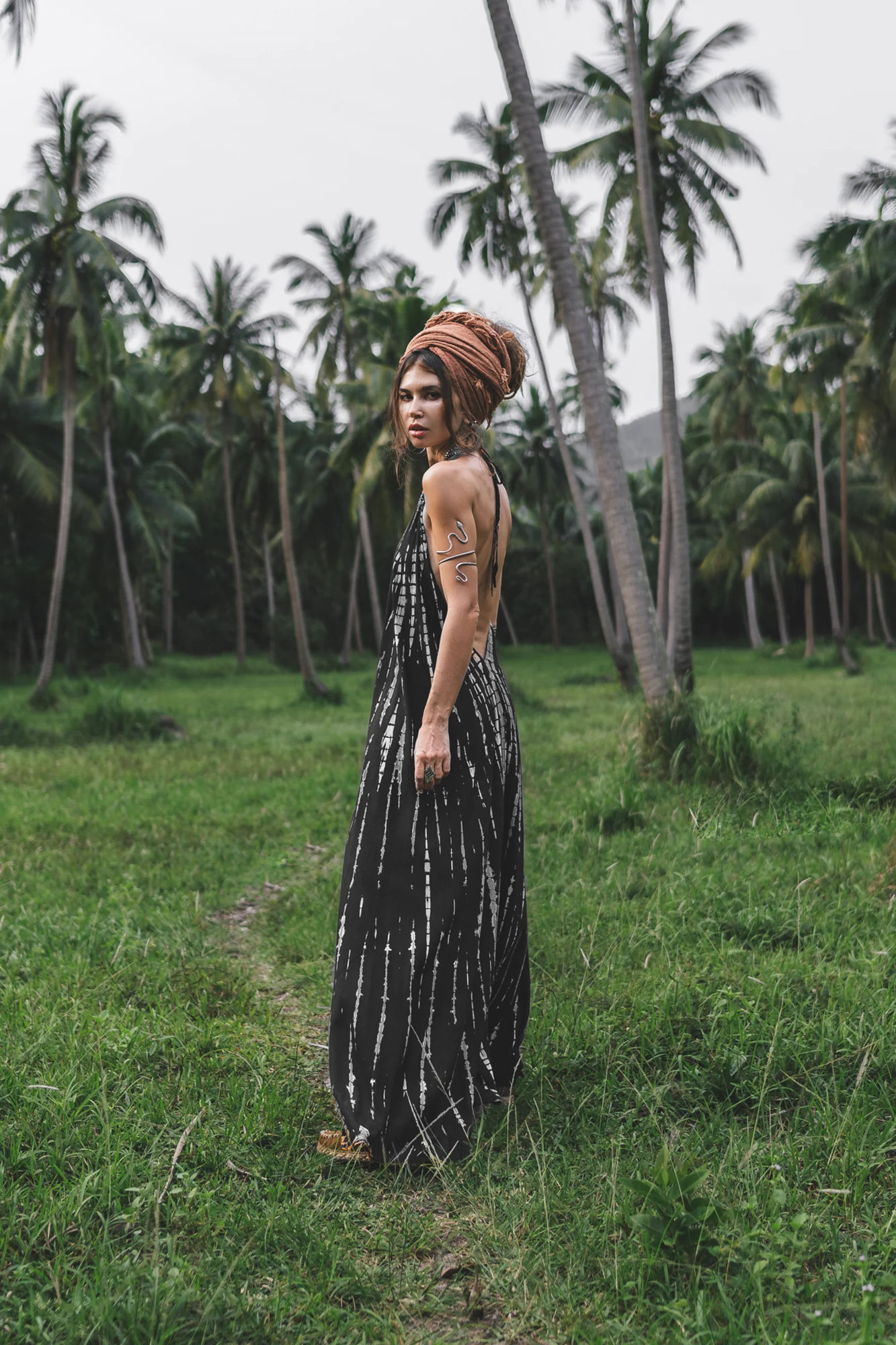 A captivating, cinematic portrait of a young mixed race witch featuring a woman with an array of intricate tattoos. She dons silver rings an...