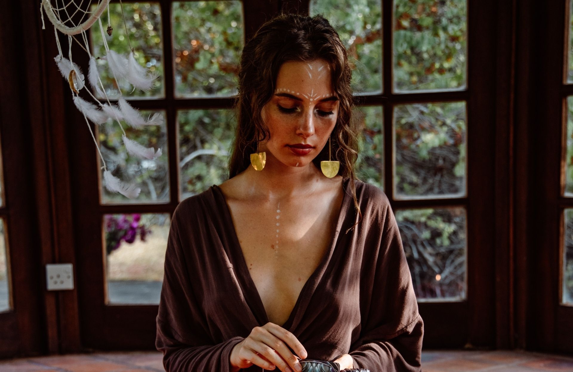 a gipsy sorcerer in her 50 sreading the future in a crystal ball , she is beautiful but frightening, her brilliant eyes sparkle with a golde...