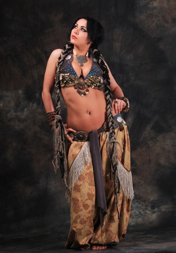 A captivating, cinematic portrait of a witch featuring a woman with cascading dark curly hair and an array of intricate tattoos. She dons si...