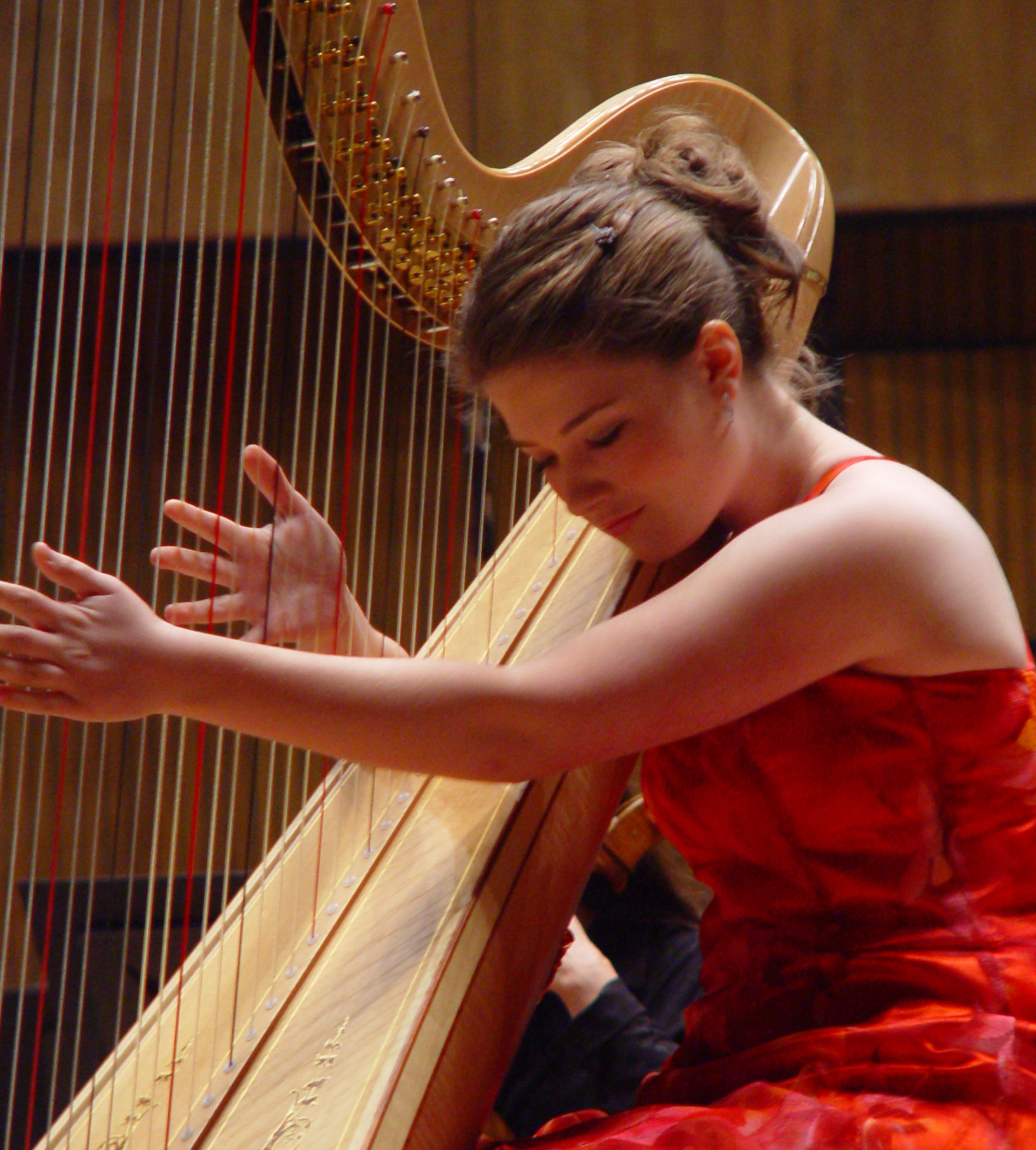 the iconic picture of a gorgeous  faerie woman playing harp,dressed with a red and black dress with laces and intricate patterns, long needl...