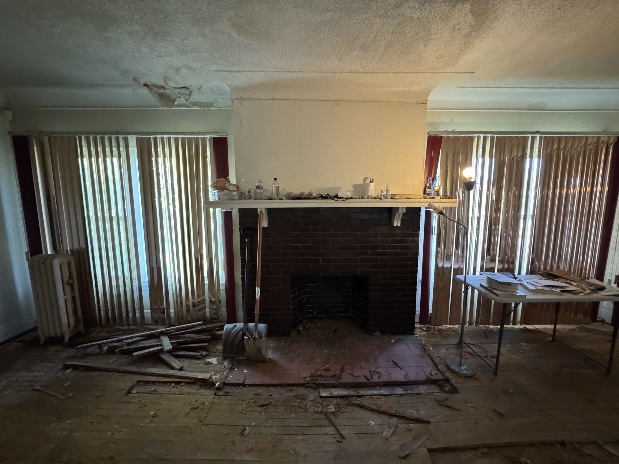 Using this exact living room photo as the base, redesign the same room in a sleek contemporary style. Keep the fireplace in its current loca...