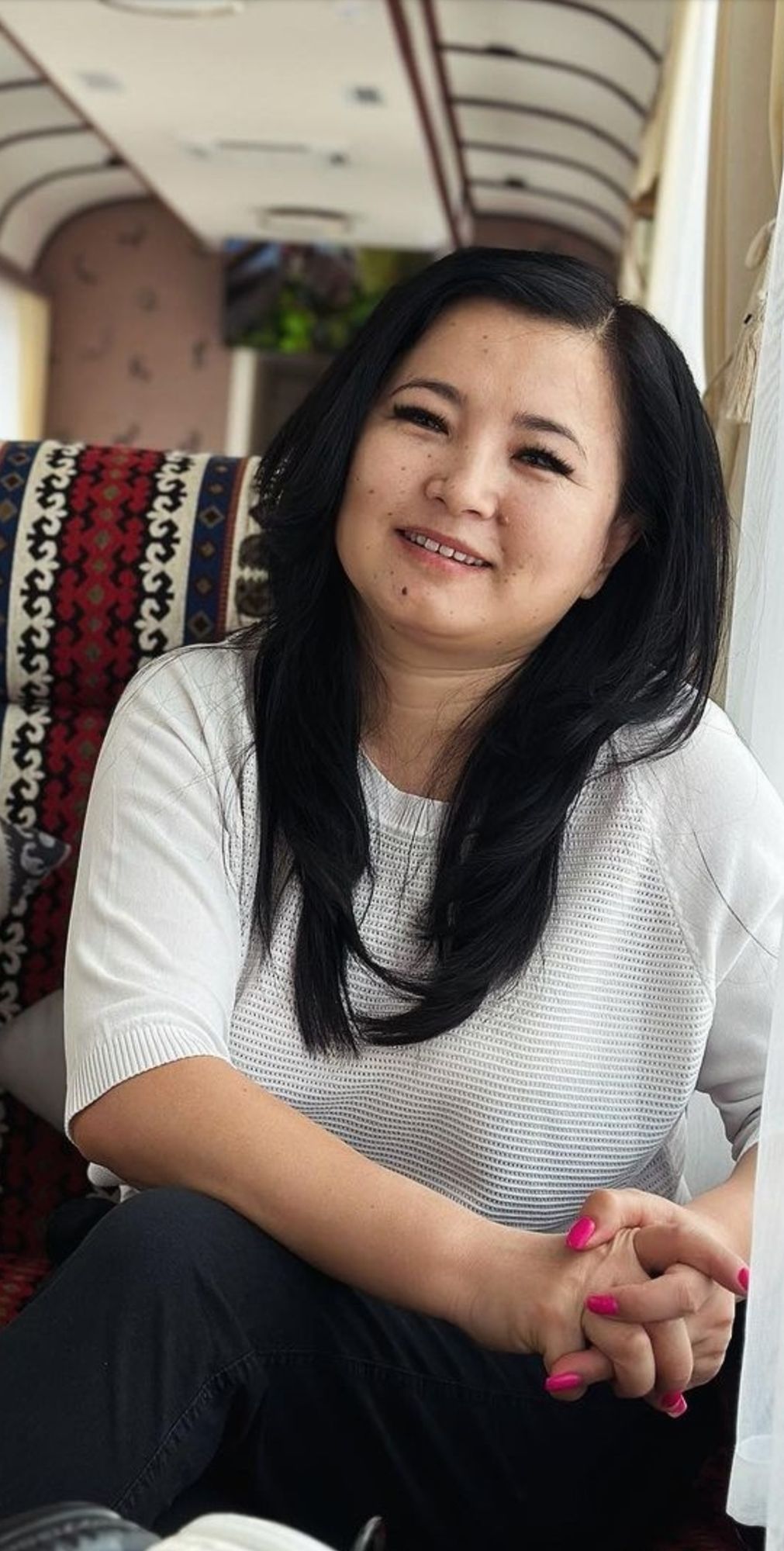  Ultra-realistic, 8K cinematic portrait of a woman sitting on a clean beach at night. She is hugging her knees, with her bare feet slightly ...